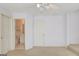 Bright bedroom leading to bathroom features a carpeted floor and a ceiling fan at 5808 Deer Crossing Dr, Sugar Hill, GA 30518