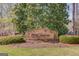 Stone sign for Wild Timber neighborhood with lush landscaping and mature trees at 5808 Deer Crossing Dr, Sugar Hill, GA 30518