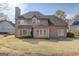 Rear exterior shot of a two-story house and a well-kept lawn at 5808 Deer Crossing Dr, Sugar Hill, GA 30518
