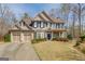 Charming two-story home with a three-car garage, manicured lawn, and a welcoming entrance at 5808 Deer Crossing Dr, Sugar Hill, GA 30518