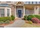Inviting front entrance with a beautiful dark blue door, stone accents, and well-maintained landscaping at 5808 Deer Crossing Dr, Sugar Hill, GA 30518