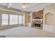 Bright living room with a stone fireplace, built-in bookshelves, and a large window bay at 5808 Deer Crossing Dr, Sugar Hill, GA 30518