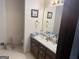 A double sink vanity with dark cabinets and neutral walls in this bathroom at 222 Farmbrook Pkwy, Stockbridge, GA 30281