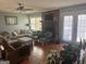 Cozy living room featuring a brick fireplace, hardwood floors, and comfortable furniture at 222 Farmbrook Pkwy, Stockbridge, GA 30281