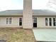Back view of home with gray siding, black door, and patio at 596 Carlton Rd, Palmetto, GA 30268