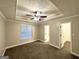 Comfortable bedroom with carpeted flooring, ceiling fan, and decorative trey ceiling at 596 Carlton Rd, Palmetto, GA 30268