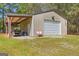 Detached garage with roll up door, covered storage, and a level lawn at 2079 Leguin Mill Rd, Locust Grove, GA 30248