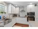 Stylish kitchen with white cabinets, stainless steel appliances, and a farmhouse sink with modern fixtures at 2079 Leguin Mill Rd, Locust Grove, GA 30248