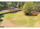 Expansive lawn featuring mature trees, wood fencing, and quaint patio area at 2079 Leguin Mill Rd, Locust Grove, GA 30248