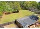 Spacious, fenced yard with mature trees surrounding a brick home with an American flag on the front porch at 2079 Leguin Mill Rd, Locust Grove, GA 30248