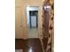 View of a hallway leading to laundry area and featuring wood flooring and door with decorative curtain at 3221 Rock Creek Dr, Rex, GA 30273