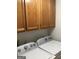 Close-up of laundry room featuring a pair of white washing machines and dark wood cabinets at 3221 Rock Creek Dr, Rex, GA 30273