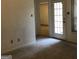 Living room featuring neutral carpet, access to additional rooms, and a glass paned door at 3221 Rock Creek Dr, Rex, GA 30273