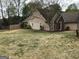 View of the yard featuring tan siding, mature trees, and a wooden fence at 3221 Rock Creek Dr, Rex, GA 30273