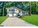 Split-level home boasts well-maintained lawn and a two car garage, nestled among mature trees at 120 Gran De, Atlanta, GA 30349