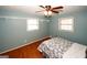 Cozy bedroom featuring hardwood floors, built-in shelving, and natural lighting from two windows at 2533 Whispering Pines Dr, Grayson, GA 30017