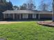 Charming brick home with a well-kept lawn and covered front porch framed with traditional columns at 2533 Whispering Pines Dr, Grayson, GA 30017