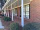 Inviting brick home featuring a covered porch with decorative columns and freshly manicured landscaping at 2533 Whispering Pines Dr, Grayson, GA 30017