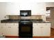 Traditional kitchen has black electric range, microwave, and white cabinets at 2533 Whispering Pines Dr, Grayson, GA 30017