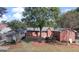 Backyard view with mature trees, brick home, detached garage, and landscaping at 2533 Whispering Pines Dr, Grayson, GA 30017