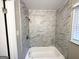 Renovated tub and shower with modern tile surround and new fixtures at 2786 Altaview Se Dr, Atlanta, GA 30354