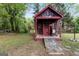 Rustic backyard shed with covered porch, ramp, and shingle accents at 4 Bonnie Glen Ln, Hampton, GA 30228