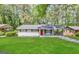 Charming single-story home with red front door, lush lawn, and attached carport at 837 Needle Rock Dr, Stone Mountain, GA 30083