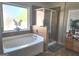 Bright bathroom featuring soaking tub, glass shower, and decorative plants with great natural light at 3620 Pickeral St, Fairburn, GA 30213