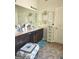Bathroom vanity area with framed art lights, dark wood cabinetry, and tile floors at 3620 Pickeral St, Fairburn, GA 30213
