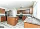 Well-equipped kitchen featuring an island, stainless steel appliances, wooden cabinets, and modern countertops at 312 Silver Fox Trl, Dallas, GA 30157