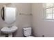 Well-lit powder room features a pedestal sink, circular mirror, and neutral color palette at 312 Silver Fox Trl, Dallas, GA 30157