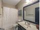 Bathroom features white vanity, framed mirror, white floral shower curtain, and tiled floor at 50 Clear Spring Ct, Oxford, GA 30054