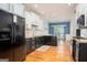 Bright kitchen with black and white cabinets, granite counters, stainless steel appliances, and hardwood floors at 50 Clear Spring Ct, Oxford, GA 30054