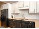 Kitchen boasts granite countertops, subway tile backsplash, black appliances, and white upper cabinets at 50 Clear Spring Ct, Oxford, GA 30054