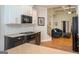 Open-concept kitchen featuring granite countertops, subway tile, black appliances, and access to living area at 50 Clear Spring Ct, Oxford, GA 30054