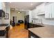 Open kitchen with granite counters, black appliances, hardwood floors, and easy access to the living area at 50 Clear Spring Ct, Oxford, GA 30054