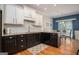 Kitchen featuring black and white cabinetry, granite countertops, subway tile backsplash, and hardwood flooring at 50 Clear Spring Ct, Oxford, GA 30054