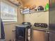 Well-lit laundry room with front-loading washer and dryer and shelving at 50 Clear Spring Ct, Oxford, GA 30054