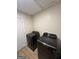 Modern laundry room featuring a front-loading washer and dryer set with matching black finish and vinyl flooring at 2900 Haddon Dr, Rex, GA 30273