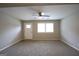 Spacious living room with neutral carpet, a ceiling fan, and a large window for ample natural light at 3410 Nw Adkins Rd, Atlanta, GA 30331
