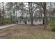 Cozy single-story home with a car port, surrounded by lush trees at 5960 John St, Austell, GA 30106