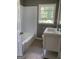 Bright bathroom with white vanity, toilet, and tiled tub with a window providing natural light at 2502 Miriam Ln, Decatur, GA 30032