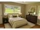 Cozy bedroom with a large window, hardwood floors, a comfortable bed, and a stylish dresser at 2502 Miriam Ln, Decatur, GA 30032