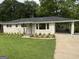 Charming home featuring a covered carport, fresh landscaping, and a welcoming blue front door at 2502 Miriam Ln, Decatur, GA 30032