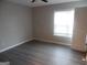 Light-filled bedroom with new vinyl plank flooring, window, and neutral wall paint at 1742 Pine Fort Cir, Dacula, GA 30019
