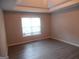 Inviting bedroom with tray ceiling, large window providing natural light, and durable vinyl plank flooring at 1742 Pine Fort Cir, Dacula, GA 30019