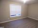 Comfortable bedroom with sleek flooring, ample lighting, and a large window for natural light at 1742 Pine Fort Cir, Dacula, GA 30019