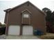 Two-car garage, side view, with complementary brown exterior at 1742 Pine Fort Cir, Dacula, GA 30019