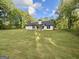 Expansive backyard featuring a well-maintained lawn, trees, and a charming single-Gathering home at 2112 Highway 54, Moreland, GA 30259