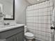 This bathroom features a gray vanity and a white toilet with shower and curtain at 2112 Highway 54, Moreland, GA 30259